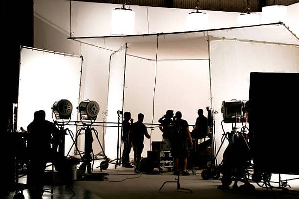 Silhouette of a production in progress on a white stage. Silhouette of a production in progress on a white stage.